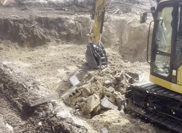 305UGC excavator removing storm debris and concrete rubble at a Florida Keys relief site
