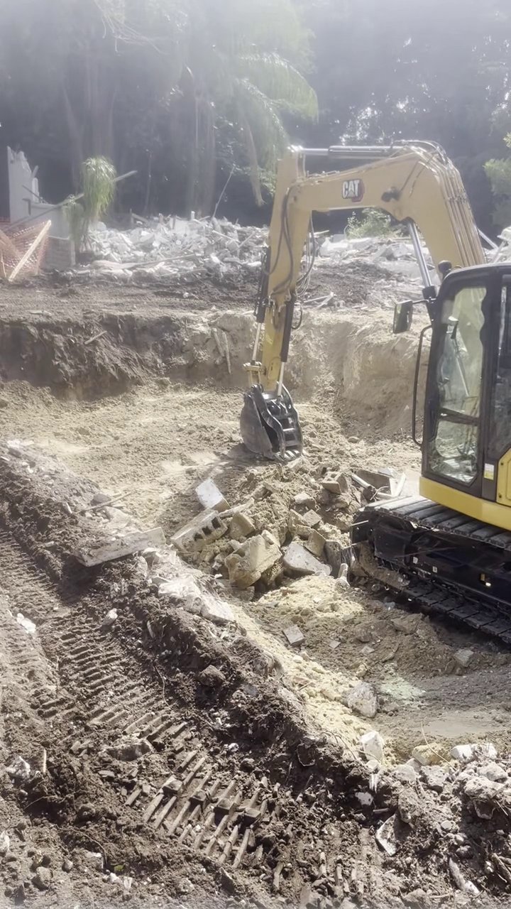 305UGC excavator removing storm debris and concrete rubble at a Florida Keys relief site